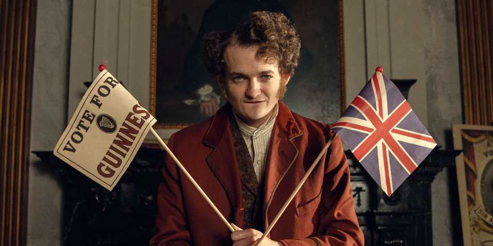 jack gleeson as byron hedges holding flags in house of guinness