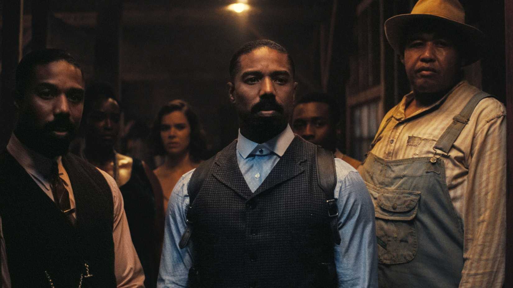 smoke stack and the others stand in the doorway of club juke looking grave in sinners