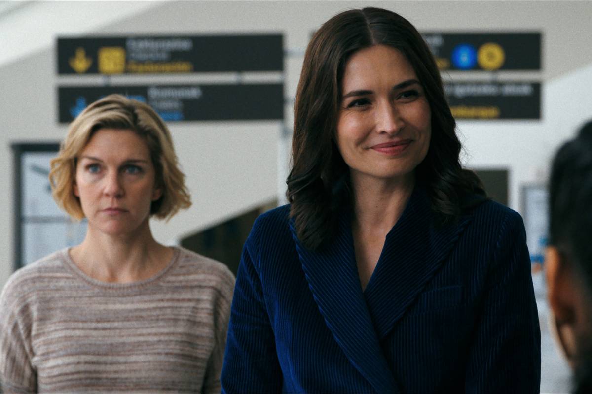 rhea seehorn s carol looking distracted and karolina wydra s zosia smiling at someone in pluribus 1