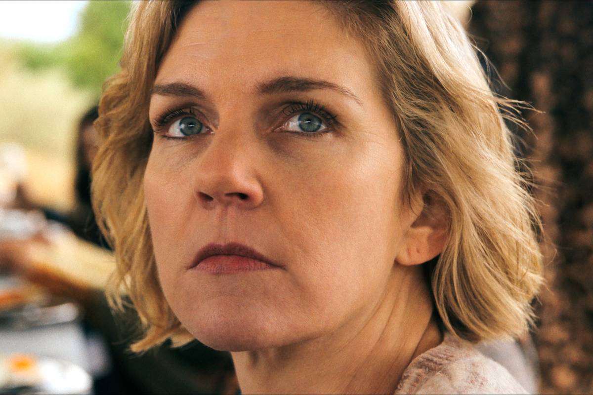 rhea seehorn s carol looking seriously over her shoulder in pluribus 1